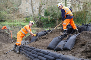 Tyler Gibson (left) and Steve Troughton use bags of soil to create new bypass channel walls